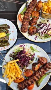 A montage of close-up shots featuring Turkish cuisine, including mixed grills, dolma, and hummus, followed by a brief shot of the restaurant interior.