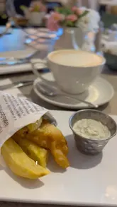 A vlog-style video showcasing a visit to Housing Units, a home decor store, where the creator and their stepdad enjoy an afternoon tea in the on-site restaurant.