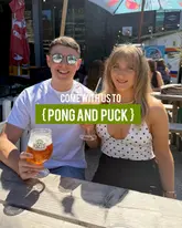 A promotional still image featuring a couple posing with drinks at an outdoor venue, with text overlay indicating the venue name.