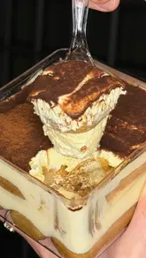 A fast-paced review of a tiramisu takeaway spot in Manchester, featuring the creator tasting various flavours including classic, pistachio, biscoff, and a salted caramel monthly special. The video highlights the unique 'secret hole' service window and the quality of the desserts.