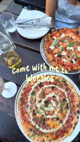 A short, energetic vlog-style video showcasing a visit to Weezies in Eccleston Yards. The video highlights the queue, the outdoor seating area, the photo booth, and the food and drink offerings, specifically focusing on their pizza and wine.