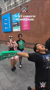 A high-energy montage capturing the atmosphere and action of a WWE live event in Birmingham, featuring crowd reactions, wrestler entrances, and the excitement of young fans.