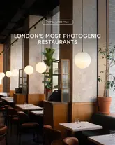 A professional, well-lit interior shot of a restaurant, used as a cover image for a listicle about photogenic dining spots in London. The image features warm, ambient lighting and a clean, balanced composition that highlights the venue's aesthetic appeal.