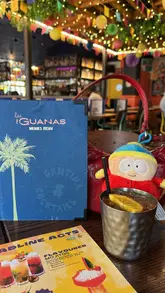 A group of friends enjoys a bottomless brunch at Las Iguanas, showcasing the venue's vibrant interior, a variety of cocktails, and main courses like burgers and quesadillas.