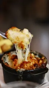 A montage of shots showcasing the exterior, interior, menu, drinks, and food at Coalhouse. The video highlights the atmosphere and specific dishes like short rib and mac and cheese.