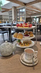 A montage showcasing an afternoon tea service at Horwood House, featuring shots of the exterior grounds, the dining room, and close-ups of the food including sandwiches, scones, and pastries.