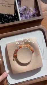 A short, aesthetic reel showcasing a cafe that offers crystal bracelet-making workshops. The video features close-up shots of the bracelet-making process, the cafe's food and drink offerings, and the overall atmosphere.