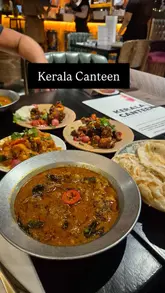 A short, engaging video featuring a creator visiting Kerala Canteen in Leeds. The video highlights the restaurant's atmosphere, interior, and a selection of their new menu items, including beef curry, paneer pepper fry, and chili and tamarind cauliflower.