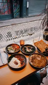 A montage video showcasing a venue that operates as a cafe by day and a wine bar by night, highlighting their evening small plates menu and wine selection.
