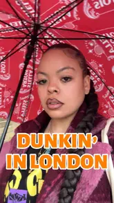 The creator visits a Dunkin' Donuts in the UK to compare it to the American version. She films the interior, the ordering kiosk, and her iced latte, providing commentary on the differences in food options and her overall impression of the visit.