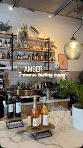 A visually appealing reel showcasing a 7-course tasting menu at a restaurant called Amber. The video features shots of the interior, the open kitchen, various dishes, and cocktails, set to music with text overlays indicating the menu and price.