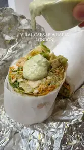 A short, high-energy clip showcasing the preparation of a Caesar wrap, focusing on the sauce application and the final product.