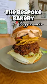 A review of The Bespoke Bakery in Biggleswade, highlighting their homemade cookies, iced lattes, and bagels. The video features the creator trying the food and giving a tour of the cozy interior.