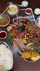 The video presents the new Mangal Sunday Roast at Royâ in Glasgow. It features a variety of shots of the large sharing platter, including close-ups of the grilled meats, sides, and dips, as well as a brief look at the restaurant's interior. The text overlay provides details about the offering and the price.