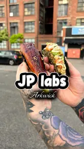 The creator reviews Japanese street food from JP Lab in Ardwick, showcasing dishes like unagi rice bowls and sushi tacos while eating them in a car park.