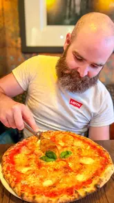 A review of 3 Blind Mice pizza restaurant and The Burrow cocktail bar in Edinburgh. The video features two creators trying various pizzas, desserts, and cocktails, highlighting the quality of the food and the cozy, intimate atmosphere of both the restaurant and the downstairs bar.