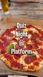 A couple visits Platform Streetfood in Cardiff Bay to participate in their weekly Wednesday quiz night, showcasing the venue's food offerings including pizza, burgers, charcuterie, and desserts.