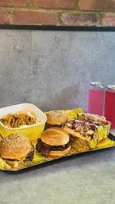 A short, rhythmic video showcasing a variety of burgers and loaded fries from Side Street. The video features close-up shots of the food being held and pulled apart, interspersed with brief glimpses of the venue's exterior and menu board.