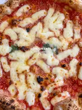 A high-quality, overhead close-up shot of a Margherita pizza, featuring text overlay indicating it is part of a 'London Eats' listicle.