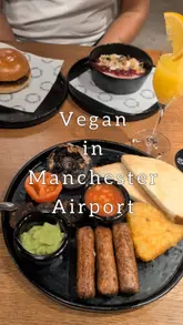A short, montage-style reel showcasing a variety of vegetarian and vegan breakfast options available at the Great Northern Market in Manchester Airport Terminal 2. The video features close-ups of a veggie breakfast, smoothie bowls, fries, and drinks, followed by a brief pan of the seating area.
