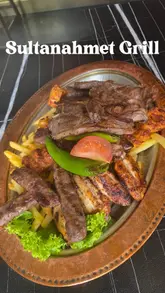A review of Sultanahmet Grill, featuring a tour of the restaurant's interior, a look at the live fire cooking in the kitchen, and a showcase of various dishes including a mezze platter, lamb moussaka, Turkish tea, and baklava.