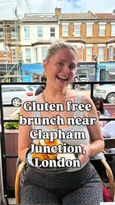 A creator reviews a brunch spot in Clapham Junction, specifically highlighting their extensive gluten-free menu options, separate fryers, and overall coeliac-friendly practices. The video features shots of the exterior, the menu, and the fried chicken and waffles dish.