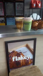 A short, visually focused reel showcasing iced matcha and latte drinks alongside filled croissants at Flakey in Manchester.