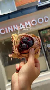 A short, punchy promotional video for a new cinnamon roll bakery in London, featuring close-ups of various flavoured rolls and specialty drinks. The video uses quick cuts to maintain high energy and focuses heavily on the visual appeal of the food, including shots of the rolls being pulled apart to show texture.