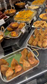 The video features a visit to the Viras Indian food counter within Harrods, showcasing the 'Create Your Own Masala Jacket Potato' concept. It highlights the various curry toppings available, such as butter chicken and lamb rogan josh, and demonstrates the assembly of the dish.