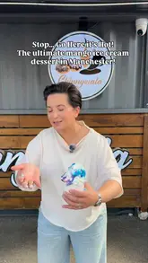 A creator reviews a dessert stall in Manchester, highlighting their signature mango-filled soft serve ice cream, strawberry and mango bowls, doughnuts, and cheesecake. The video features the preparation process and the creator's enthusiastic reaction to the food.