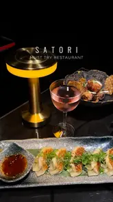 A high-quality, polished promotional reel for Satori, a Japanese restaurant in Birmingham. The video features a montage of beautifully plated dishes including sushi, wagyu, and dessert, interspersed with shots of the restaurant's interior and the creator enjoying a drink. The editing is rhythmic and professional, focusing on the aesthetic appeal of the food and the exclusive atmosphere.