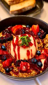 A promotional reel for a new brunch venue called DAU'N in Hall Green, Birmingham. The video features a montage of the exterior, the menu, the interior seating area, and various food and drink items including a matcha latte, a breakfast platter, a berry yogurt bowl, and a shakshuka-style dish.