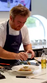A montage showcasing a trip to Padstow, featuring a fishing excursion, a picnic, a cooking class at the Rick Stein Cookery School, and dining at The Seafood Restaurant.