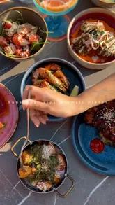 A montage video showcasing a variety of small plates and cocktails at Voyagers, located in The Halyard Hotel. The video features close-up shots of dishes like crispy gnocchi, Korean fried chicken, and various spritzes, interspersed with shots of the venue's interior and outdoor terrace.