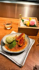 A montage of various dishes served at ROKA, a Japanese Robatayaki restaurant in Mayfair, London. The video features close-ups of grilled octopus, black cod, fillet steak, and a pistachio crème brûlée, alongside shots of the open kitchen and charcoal grill.