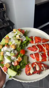 A short, top-down video demonstrating the preparation of a salad with grilled chicken, featuring text overlays and music.