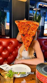 A short, energetic review of 'Goldies' in Liverpool, featuring the creator trying various New York-style pizza slices, including a hot honey pepperoni option, alongside cocktails and sides. The video highlights the venue's interior, including booth seating and a bar area, while providing a clear recommendation for viewers.