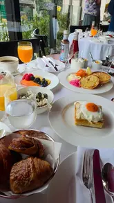 A short, aesthetic montage showcasing a breakfast spread at Cafe Clement in London. The video features high-quality shots of pastries, coffee, fruit, and cooked breakfast dishes, highlighting the elegant presentation and the venue's outdoor seating area.