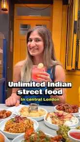 A creator reviews an unlimited Indian street food deal at a restaurant called Papadum in London. The video features the creator explaining the offer, showing the menu, and displaying various dishes like samosa, vada pav, and chili paneer, while also showing kitchen preparation footage.