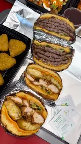 A review of The Burger Firm, showcasing their menu, interior, and specific dishes like the 4x4 smash burger, mac and cheese triangles, and halloumi fries.