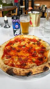 A couple visits Caesar's Social in Glasgow to review their 'Guilty Pleasure' pizza and non-alcoholic beer. The video features close-ups of the pizza, the dipping sauce, and the creators enjoying their meal, providing a personal and enthusiastic recommendation.