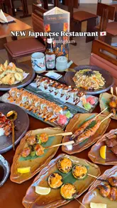 A montage-style video showcasing a variety of Japanese dishes, including yakitori skewers, sushi rolls, tempura, and udon noodles, at a new restaurant in Birmingham. The video focuses on close-up, well-lit shots of the food, with brief glimpses of the restaurant's interior and exterior.