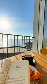 A short, aesthetic montage showcasing a cafe with a sea view in Dún Laoghaire, Dublin, featuring coffee and a croissant.