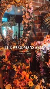 A montage-style video showcasing the interior and outdoor dining areas of The Woodmans Arms, featuring clips of the Sunday lunch menu, including starters, roast dinners, and desserts.