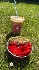 A creator visits The Boathouse Cafe in Antrim, Northern Ireland, to review their açai bowls. The video features shots of the scenic waterside location, the cafe's exterior, the menu, and a taste test of the 'Dubai' açai bowl and an iced latte.