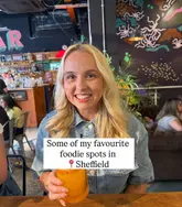A creator-led listicle post featuring a selfie of the creator holding a cocktail in a hospitality venue, used as a cover image for a recommendation list of Sheffield foodie spots.