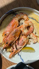 A short, visually focused reel showcasing a seafood restaurant in Brighton. The video features close-up shots of various dishes, including prawns, scallops, and a dessert, along with a brief exterior shot of the venue.