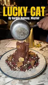 A creator visits Lucky Cat by Gordon Ramsay in Mayfair, showcasing the interior, the chefs at work, and several dishes including nigiri, short rib bao, grilled Madagascan prawn, and a signature chocolate lucky cat dessert.