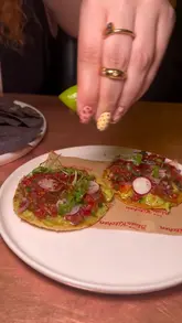 A vlog-style review of The Blues Kitchen in Manchester, featuring a variety of dishes including spinach artichoke dip, tacos, steak, mac and cheese, and a cookie dessert, alongside cocktails and live music.