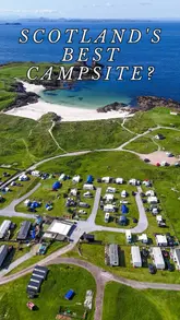 A review of Clachtoll Beach Campsite on the North Coast 500 in Scotland, highlighting its extensive facilities including free water sports equipment, an honesty fridge, a communal kitchen with a log burner, a sauna, and fresh local seafood.
